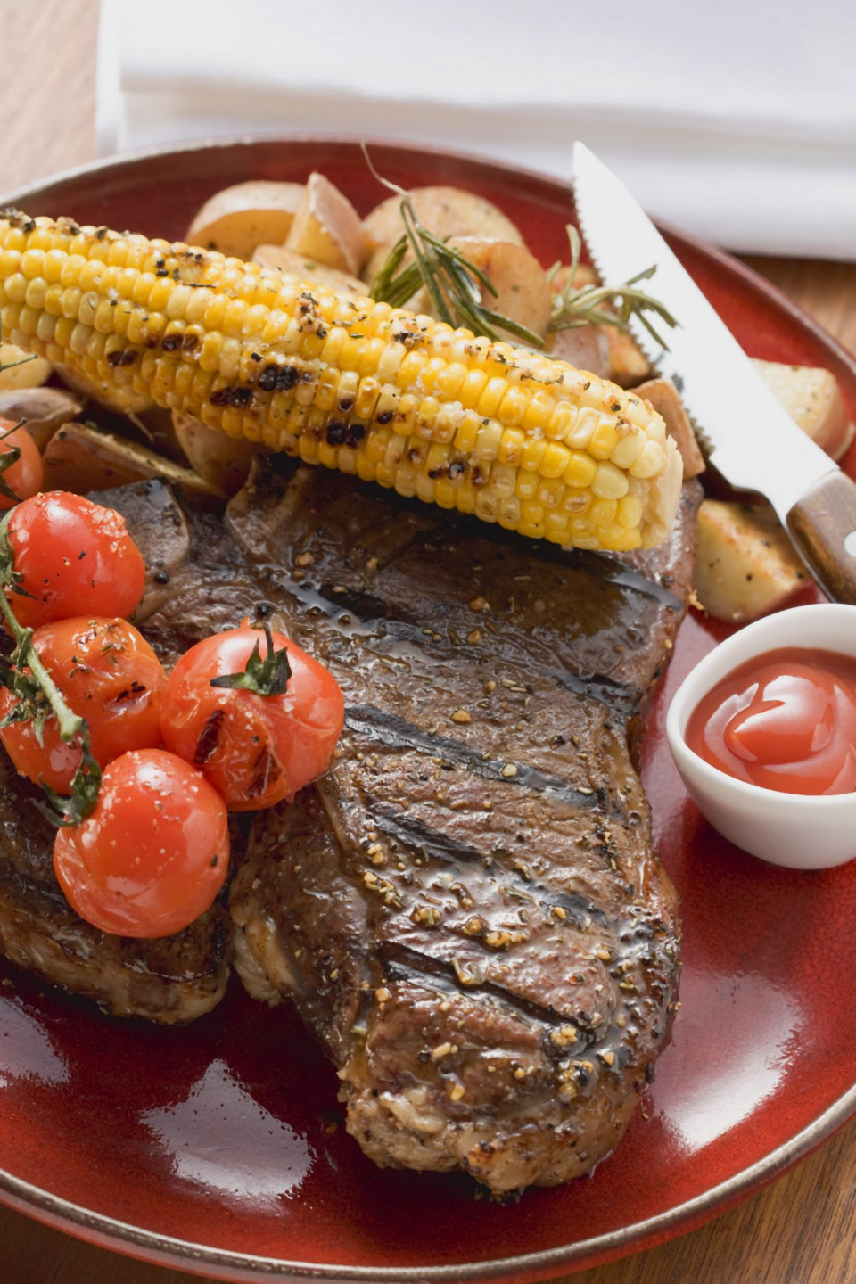 Bio Gegrilltes Steak mit Maiskolben, Cherrytomaten, Kartoffeln und Ketchup